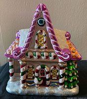Front view of Radko gingerbread house cookie jar showing candy details and glitter