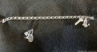 Full view of sterling silver link charm bracelet showing length and attached charms