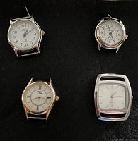 Four watch heads showing dial details and cases