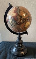Front view of globe showing Asia-Australia, painted pedestal base