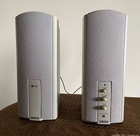Front view of both Yamaha grey bookshelf speakers with controls visible