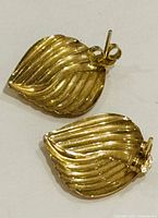 Pair of 10K yellow gold leaf-shaped earrings showing ribbed detailing and post back clasps.
