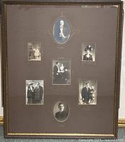 Large framed display containing seven vintage black and white photos mounted on brown mat with gold accents