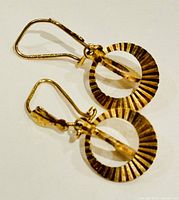 Side and front view of the pair of 9K yellow gold earrings showing the circular ridged design and hook closure.