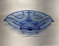 Blue translucent Art Deco style pressed glass bowl, showing geometric and textured pattern, three rim protrusions, smooth polished surface.