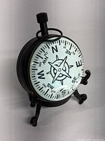 Front view of compass ball showing compass rose and black metal stand with knob on top