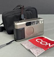 Front view of Contax T2 camera with carrying case and manual