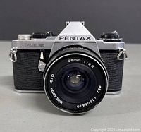 Front view of Pentax ME Super film camera with attached Soligor 28mm f/2.8 lens showing lens front glass, markings, and body textured grip.