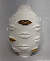 Front view of white porcelain vase with gold gilded lips embossed on surface