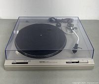 Front view of Technics SL-B202 turntable with dust cover on, showing speed selector and controls on front panel.