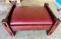Top-down view of the wooden bench with deep red vinyl upholstery and visible tenon joinery on the legs and sides.