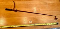 Full length of riding crop showing leather-wrapped handle, long slender shaft, and taped tip approximately 27 inches long.