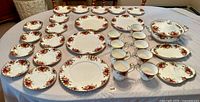 Full set of Royal Albert Old Country Roses bone china 30 pieces arranged on table: teacups, saucers, salad plates, dinner plates, covered tureen, oval platter, candy dish.