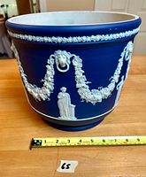 Side view of cobalt blue Jasperware planter with white relief motifs and measuring tape indicating approx. 9 inch diameter