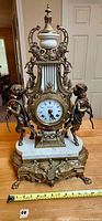 Full front view of ornate mantel clock on table