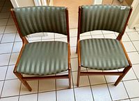 Top view of both dining chairs showing sage green striped seats and backs on wooden frames.