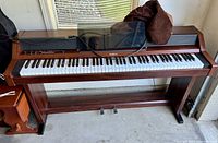 Full frontal view of the Roland PianoPlus 450 piano/organ showing wooden cabinet, keyboard, and foot pedals.