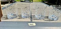 Photo showing all four cut crystal old fashioned glasses lined up outdoors with sunlight enhancing the patterns.