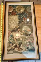 Front-facing photo of framed Victorian chromolithograph print showing woman with goldfish bowl and detailed background including ceramics and tapestries.