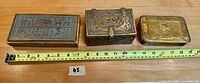 Three brass boxes displayed side by side measuring around 18 inches total length with a tape measure included for scale.