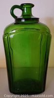 Front angled view of green glass jug