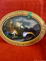 Front view of oval framed landscape print