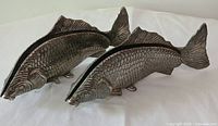 Both fish shaped silver plated holders side by side showing scale detail and top slot