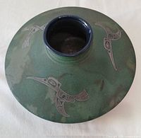 Top view of green raku vase showing bird motifs and narrow blue rim