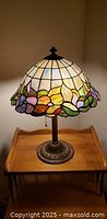 Assembled lamp on table showing stained glass shade and metal base