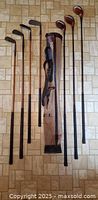 Seven wooden shaft golf clubs and canvas bag laid out