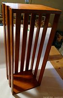 Full view of wooden slatted magazine/display rack showing construction and finish