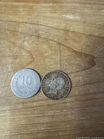 Both coins obverse sides, right coin shows bust and date 1985, left coin reverse worn
