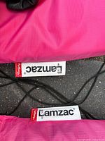 Close-up of Lamzac Fatboy brand labels on pink fabric and black cords