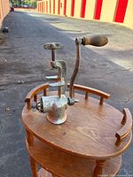 Side view of cast iron meat grinder showing clamp, crank arm and wood handle