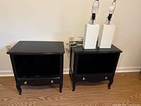 Two matching black Century nightstands side by side, lamps shown are not included