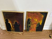 Both framed firefighter paintings standing side by side