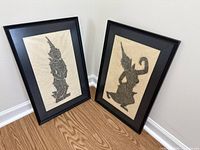 Both framed artworks leaning against wall