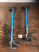 Two blue telescoping cabinet jacks showing full length and adjustment mechanisms