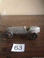 Left side view of cast aluminum race car showing body shape and wheels