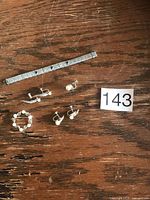 Overall lot showing bracelet, three pairs screw-back earrings, pearl brooch next to lot number