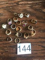 Group shot of approx. 18 rings laid out on wooden surface