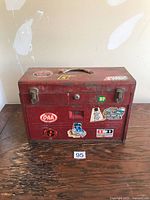 front view of red toolbox with stickers and handle