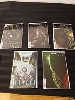 Five bagged and boarded Alien #1 variant comics displayed on table