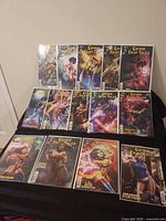 All 13 bagged comic books displayed on black surface