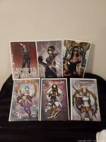 Front view of six bagged comic books: Jennifer Blood Battle Cry #2 variant, Honey Collision Course #4 variant, and four Lady Mechanika issues