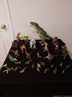 Overall view of all dinosaur figures on black cloth