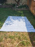 Outdoor rug laid flat on grass showing full design and size