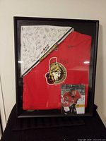 Front view of framed jersey, towel and photo