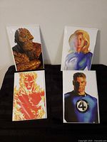 All four bagged comic covers arranged, each showing a different Fantastic Four character
