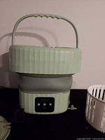 Front view of HIKELA collapsible washer showing control panel and handle